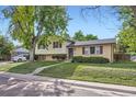 Street view of two-story home with brick facade, tidy landscaping, and sidewalk at 11797 Keough Dr, Northglenn, CO 80233