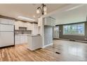 Bright, open kitchen features white cabinets, hardwood floors, stainless steel appliances, and natural light from a skylight at 2965 S Birch St, Denver, CO 80222