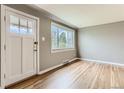 Bright, open living room with a beautiful hardwood floor, large window, and freshly painted walls at 2965 S Birch St, Denver, CO 80222