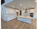 Spacious kitchen featuring white cabinets, stainless steel appliances, and a center island with sink at 7291 Prairie Sage Pl, Littleton, CO 80125