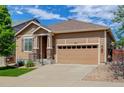 Charming tan-colored home with a two-car garage, a covered entry, and well-maintained landscaping at 1462 Raindrop Way, Castle Rock, CO 80109