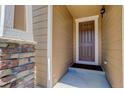 Close-up of a dark brown front door with stone pillars, adding character to this charming home's entrance at 1462 Raindrop Way, Castle Rock, CO 80109