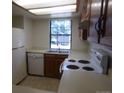 Well-lit kitchen with white appliances, a window above the sink, and wooden cabinetry at 453 S Kittredge St # D, Aurora, CO 80017