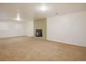 Bright basement featuring neutral carpet, a brick fireplace, and natural light from a large window at 3273 S Florence Ct, Denver, CO 80231