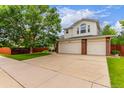 Charming two-story home with a well-maintained lawn and a spacious three-car garage at 12825 Forest Way, Thornton, CO 80241