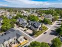 Aerial view of townhomes in a suburban neighborhood with mature trees and well-maintained streets at 4825 S Ammons St # 102, Littleton, CO 80123