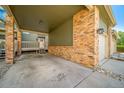Covered entry featuring brick pillars, porch, and a white front door, providing sheltered access to the home at 4825 S Ammons St # 102, Littleton, CO 80123