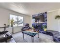 Modern living room with a fireplace, large window, and stylish decor at 11964 W 71St Pl, Arvada, CO 80004