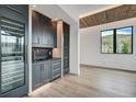 Bar area with wine refrigerators, sink, dark cabinetry, and wood accent ceiling at 294 Gold Run Rd, Breckenridge, CO 80424