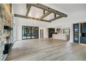 Spacious open concept living room with wood floors, stone fireplace, and exposed beam ceiling at 294 Gold Run Rd, Breckenridge, CO 80424