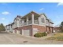 Stylish condo exterior showing a two-story design, brick facade, and attached garage at 74 Whitehaven Cir, Highlands Ranch, CO 80129