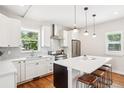 Modern kitchen features white cabinets, stainless steel appliances, a large island with seating, and hardwood floors at 4603 W 33Rd Ave, Denver, CO 80212