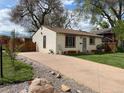 Quaint one-story home with a spacious driveway, well-kept lawn, and charming exterior details at 4825 Estes St, Arvada, CO 80002