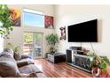 Bright living room with wood floors, a fireplace, large windows, and access to a deck at 633 W 114Th Way, Northglenn, CO 80234