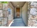 Inviting stone accented front entryway with steps leading to a wooden front door at 2347 S Loveland St, Lakewood, CO 80228