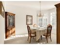 Bright dining room with elegant chandelier, shutters, and classic wooden furniture set on carpet at 5208 Shetland Ct, Highlands Ranch, CO 80130