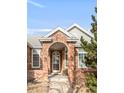 Close-up view of the home's arched brick entryway and beautifully designed front door with sidelights at 5208 Shetland Ct, Highlands Ranch, CO 80130