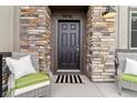 Charming front entrance with decorative stonework and cozy seating at 9836 Mount Kataka Pt, Littleton, CO 80125