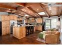 Gourmet kitchen featuring wood cabinetry, a center island with seating, and stainless steel appliances at 10220 W Montgomery Ave, Littleton, CO 80127