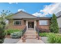 Inviting front exterior with beautiful landscaping, flowers, and a stone facade at 2539 N York St, Denver, CO 80205