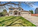 Inviting two-story home with brick and siding, a three-car garage, and a lush green lawn at 9411 La Quinta Way, Lone Tree, CO 80124