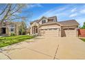 Beautiful two-story home featuring a three-car garage, and a well-manicured lawn at 9411 La Quinta Way, Lone Tree, CO 80124