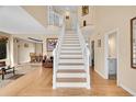 Bright foyer with hardwood floors, staircase, and views into the living and dining areas at 9411 La Quinta Way, Lone Tree, CO 80124