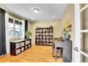 Bright room with hardwood floors, bookshelves, and a piano at 5478 Teton Dr, Longmont, CO 80504