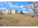 Low angle full building exterior view of a condominium with parking visible on a sunny day with blue skies at 7780 W 38Th Ave # 203, Wheat Ridge, CO 80033