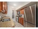 Kitchen with stainless steel appliances, granite counters and wood cabinets at 865 S Quebec St # 103B, Denver, CO 80247