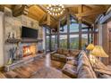 Living room with a stone fireplace, vaulted wood ceilings, and large windows with a mountain view at 242 Point View Pl, Breckenridge, CO 80424