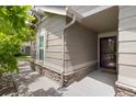 Inviting front porch with neutral siding and stone base offers a welcoming entry at 22044 E Jamison Pl, Aurora, CO 80016