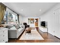 Bright living room featuring hardwood floors, a comfortable sofa, and plenty of natural light at 1671 S Chase St, Lakewood, CO 80232