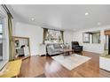 Comfortable living room with hardwood floors, ample seating, and a large window with backyard view at 1671 S Chase St, Lakewood, CO 80232