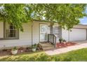 Inviting front entrance with a decorative door and tasteful landscaping with potted plants at 3358 S Iris Ct, Lakewood, CO 80227