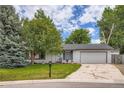 Charming single story home featuring an attached two car garage and lush lawn at 3358 S Iris Ct, Lakewood, CO 80227