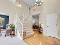 Inviting entryway with light wood floors, staircase and view into other rooms at 7138 Mountain Brush Cir, Highlands Ranch, CO 80130