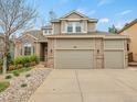 A two-story home showcasing a three car garage and a brick and siding exterior at 7138 Mountain Brush Cir, Highlands Ranch, CO 80130