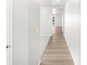 Bright hallway with wood floors leading to carpeted area and view to backyard at 17487 E 89Th Way, Commerce City, CO 80022