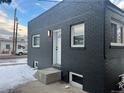 This house showcases a striking black brick exterior with white trimmed windows, and a stylish front door entrance at 20 E 45Th Ave, Denver, CO 80216