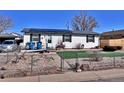 Inviting home with solar panels, a ramp, and fenced yard for privacy and curb appeal at 6060 Locust St, Commerce City, CO 80022