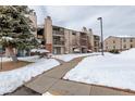 Exterior view of the apartment building showcasing the building's facade with a sidewalk covered in snow at 539 Wright St # 102, Lakewood, CO 80228