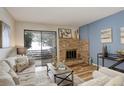 Comfortable living room featuring a stone fireplace, wood floors, and sliding glass doors to the outside at 539 Wright St # 102, Lakewood, CO 80228