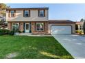 Traditional home with brick and vinyl siding and a freshly cut lawn at 8538 W Glasgow Pl, Littleton, CO 80128