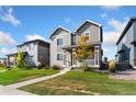 Attractive two-story home featuring a covered porch and lush green lawn at 18060 E 106Th Pl, Commerce City, CO 80022