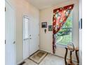 Inviting entryway with tile flooring, a white front door, and a side table at 6626 S Reed Way # A, Littleton, CO 80123