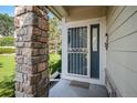 Close up of front porch featuring a gray security door and stone pillar at 6626 S Reed Way # A, Littleton, CO 80123