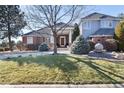 Beautiful home exterior with mature landscaping and circular driveway at 73 Falcon Hills Dr, Highlands Ranch, CO 80126