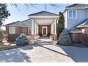 Inviting home entrance with covered portico and brick facade at 73 Falcon Hills Dr, Highlands Ranch, CO 80126