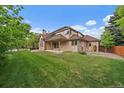Large backyard featuring a well-maintained lawn and covered patio, perfect for outdoor entertaining at 7914 S Clayton Cir, Centennial, CO 80122